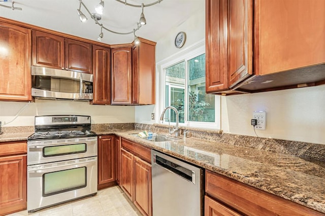 kitchen with light tile patterned flooring, stainless steel appliances, sink, and stone countertops