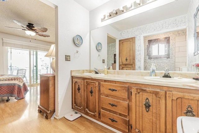 bathroom with a textured ceiling, vanity, ceiling fan, and hardwood / wood-style flooring