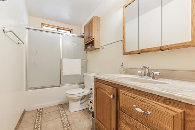 full bathroom with tile patterned flooring, bath / shower combo with glass door, vanity, and toilet