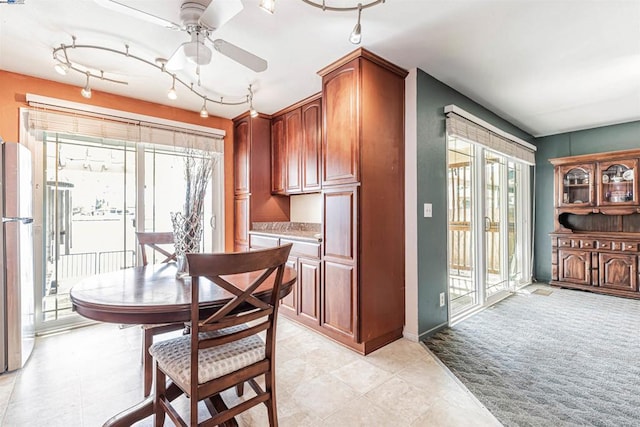 carpeted dining area featuring ceiling fan and track lighting