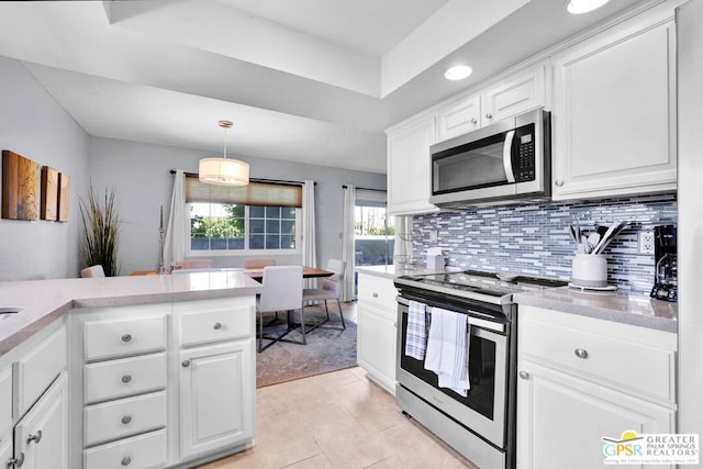 kitchen featuring white cabinets, light tile patterned flooring, stainless steel appliances, and pendant lighting