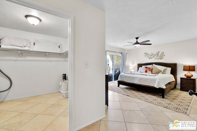 bedroom with a textured ceiling, light tile patterned floors, ceiling fan, and a closet