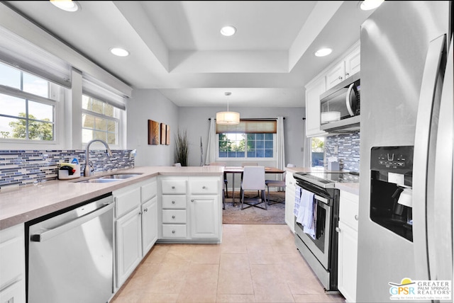 kitchen with white cabinets, appliances with stainless steel finishes, and plenty of natural light