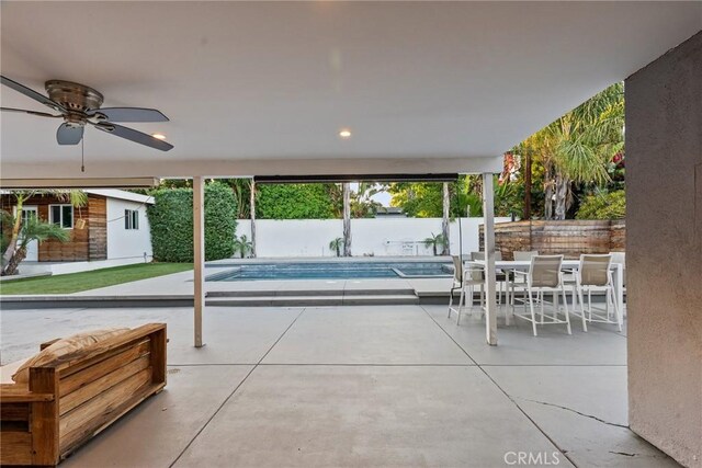 view of patio with a fenced in pool, ceiling fan, and an outdoor structure