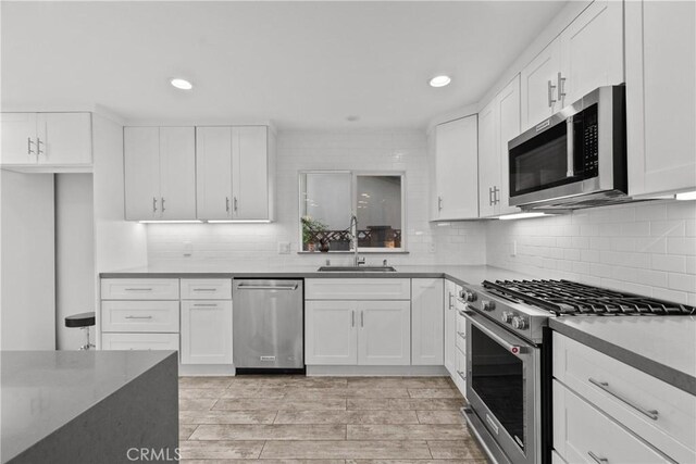 kitchen with white cabinets, stainless steel appliances, and light wood-type flooring