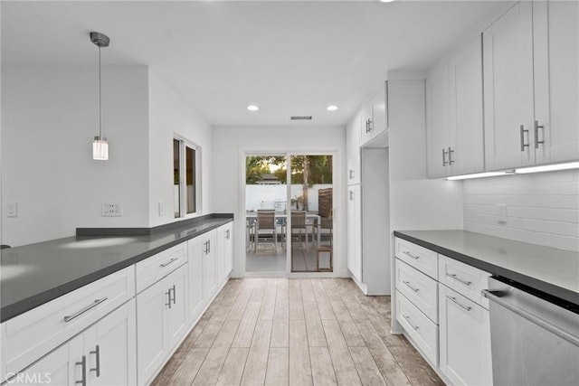 kitchen featuring white cabinetry, pendant lighting, stainless steel dishwasher, and light wood-type flooring