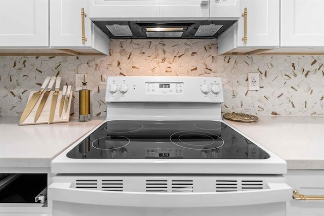 interior details with range, backsplash, exhaust hood, and white cabinets