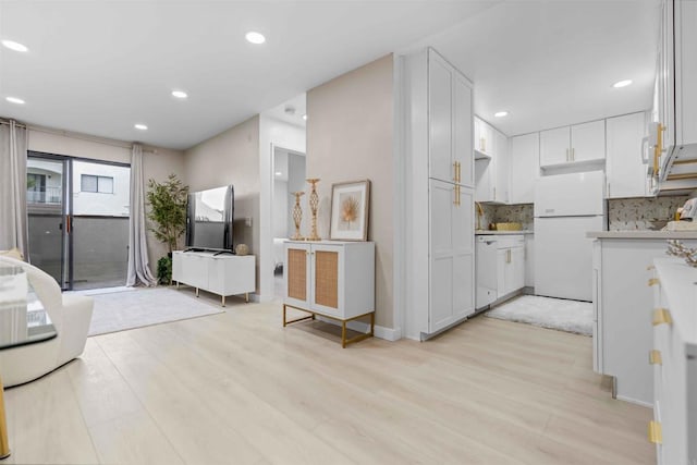 kitchen featuring light wood-type flooring, white appliances, and white cabinetry