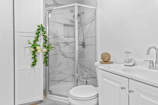 bathroom featuring an enclosed shower, vanity, and toilet