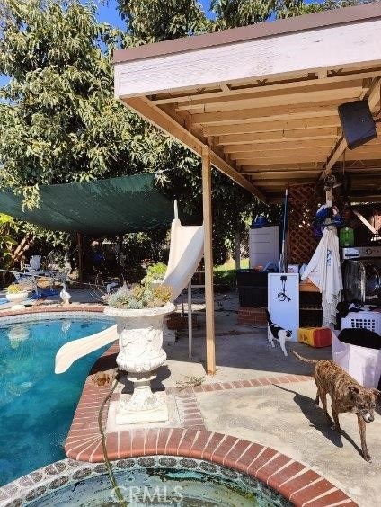 view of patio featuring a pool with hot tub