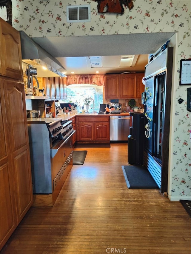 kitchen featuring sink, light hardwood / wood-style floors, and stainless steel dishwasher