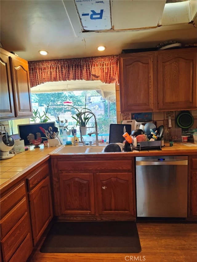 kitchen with tile counters, stainless steel dishwasher, dark hardwood / wood-style floors, and sink