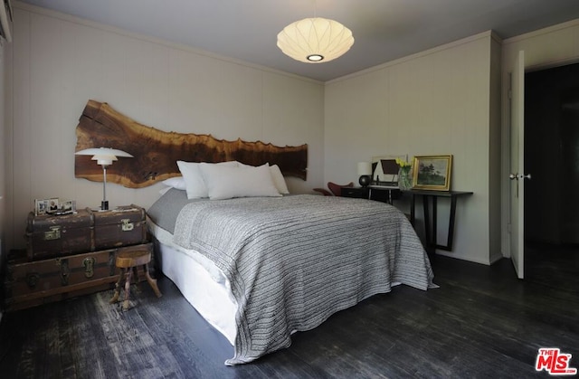 bedroom with ornamental molding and dark hardwood / wood-style flooring