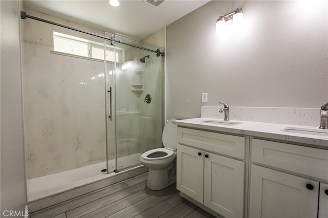 bathroom featuring vanity, toilet, an enclosed shower, and hardwood / wood-style flooring