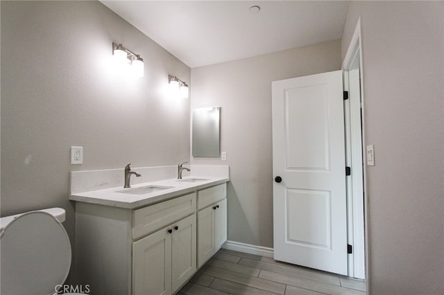 bathroom with vanity, toilet, and hardwood / wood-style flooring