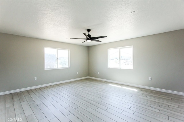 empty room with ceiling fan, a textured ceiling, and light hardwood / wood-style floors