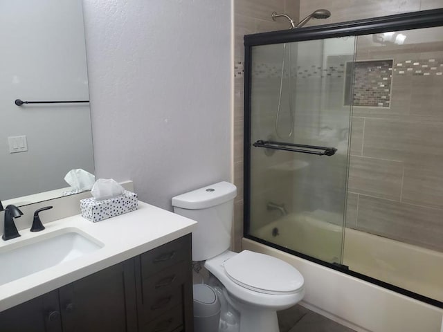 full bathroom with vanity, shower / bath combination with glass door, and toilet