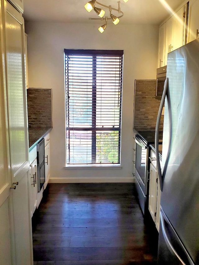 kitchen featuring dark hardwood / wood-style floors, a notable chandelier, beverage cooler, white cabinets, and stainless steel refrigerator