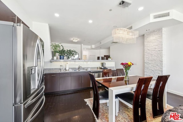 dining room with dark hardwood / wood-style floors, sink, and a notable chandelier