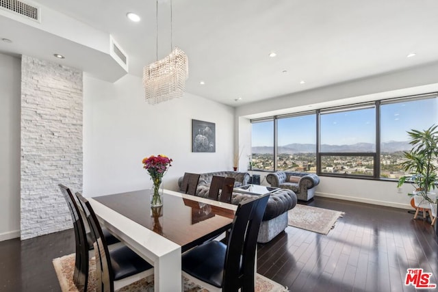 dining room featuring a mountain view, an inviting chandelier, and dark wood-type flooring