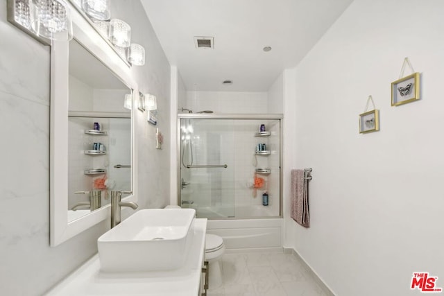 full bathroom featuring shower / bath combination with glass door, vanity, and toilet