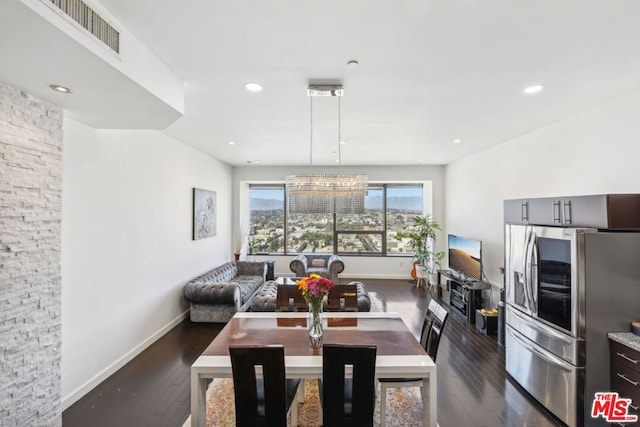 dining area featuring a notable chandelier and dark hardwood / wood-style flooring