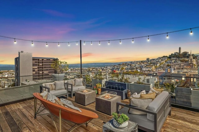 deck at dusk featuring an outdoor living space with a fire pit