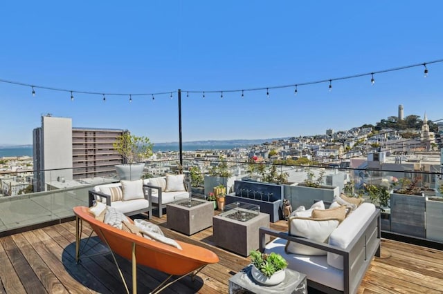 deck featuring a water view and an outdoor living space with a fire pit