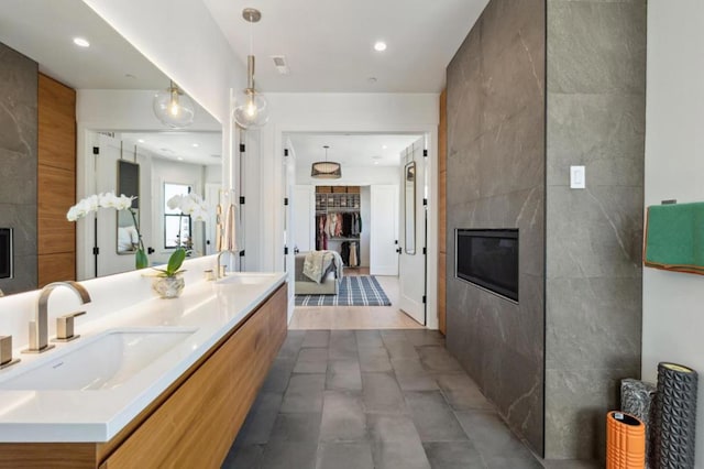 bathroom featuring vanity, a high end fireplace, and tile walls