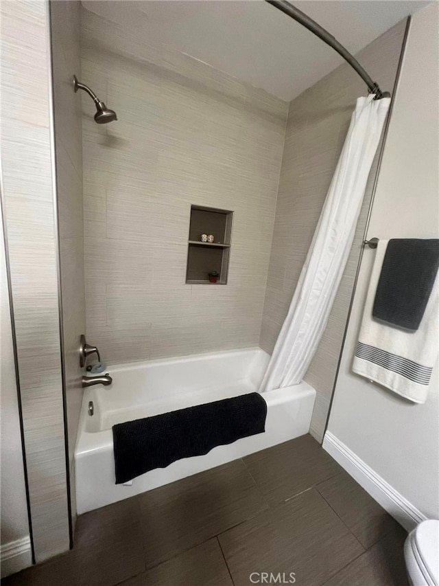 bathroom with shower / tub combo and toilet