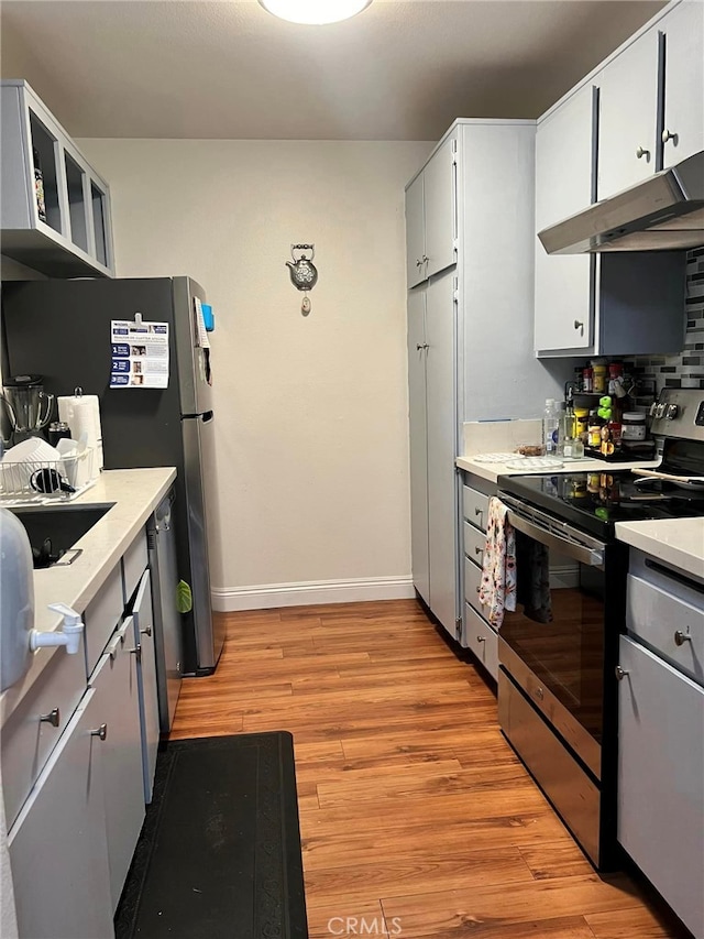 kitchen with light hardwood / wood-style floors, white cabinetry, and appliances with stainless steel finishes