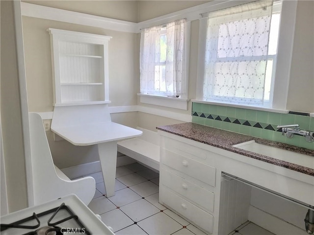 unfurnished office featuring sink and light tile patterned flooring