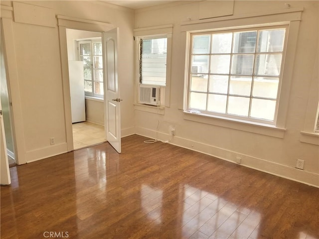 unfurnished room featuring hardwood / wood-style floors, a healthy amount of sunlight, and cooling unit