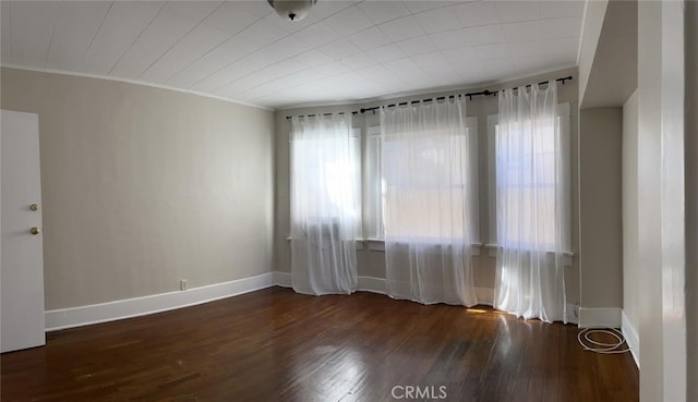 unfurnished room featuring dark hardwood / wood-style floors and ornamental molding