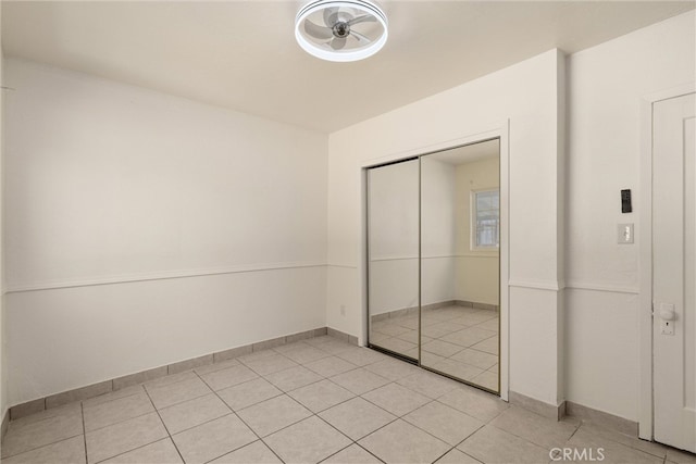 unfurnished bedroom with a closet and light tile patterned floors