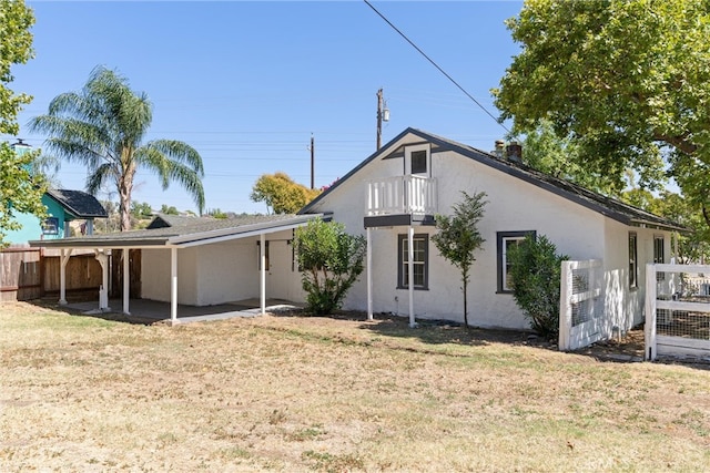 rear view of house featuring a lawn and a patio