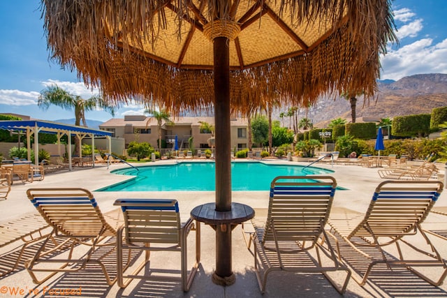 view of swimming pool with a mountain view and a patio area