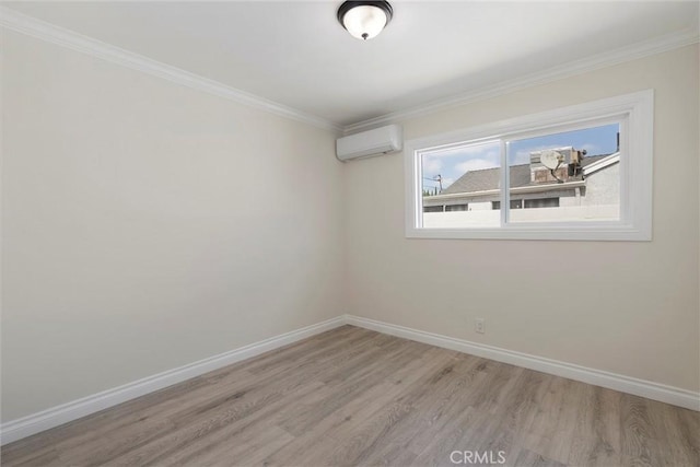 empty room featuring light hardwood / wood-style floors, ornamental molding, and a wall unit AC