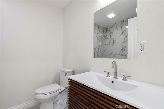 bathroom with toilet, vanity, and tiled shower