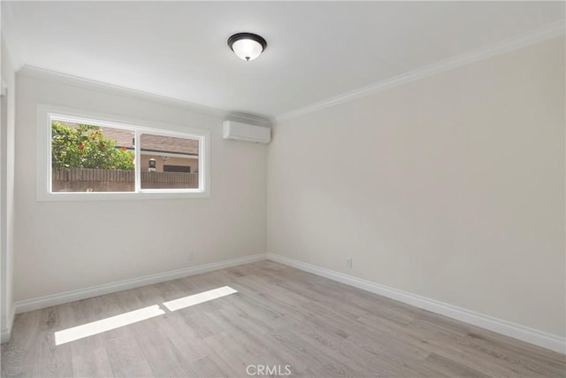 empty room with a wall mounted AC, ornamental molding, and light hardwood / wood-style flooring