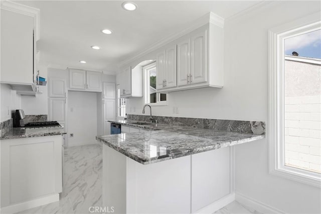 kitchen featuring white cabinetry, kitchen peninsula, and dark stone counters