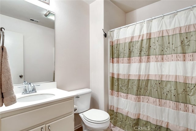 bathroom with curtained shower, vanity, and toilet