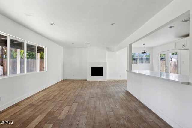 unfurnished living room featuring wood-type flooring and plenty of natural light