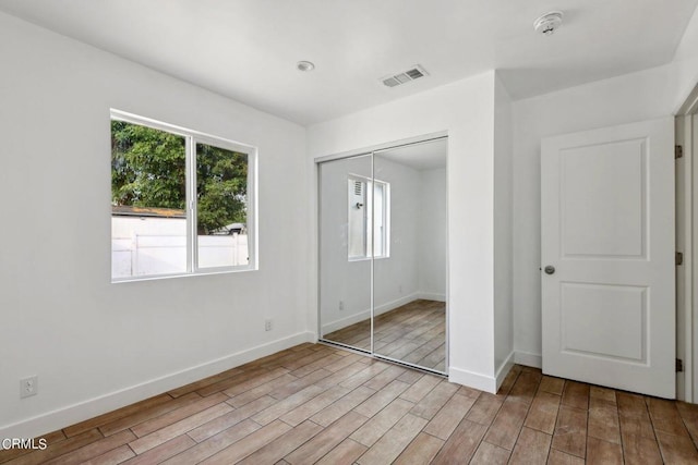 unfurnished bedroom with a closet and light wood-type flooring