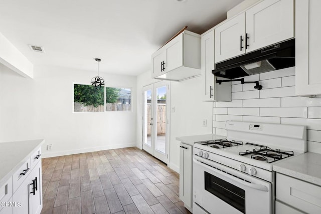 kitchen featuring white gas range, light hardwood / wood-style flooring, backsplash, decorative light fixtures, and white cabinets