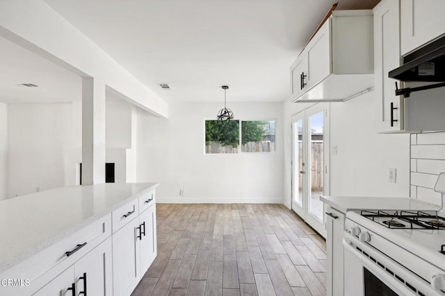 kitchen featuring backsplash, hardwood / wood-style floors, white cabinetry, white range with gas cooktop, and light stone counters