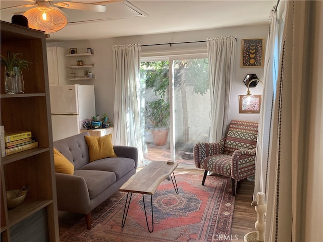 sitting room with ceiling fan and hardwood / wood-style floors