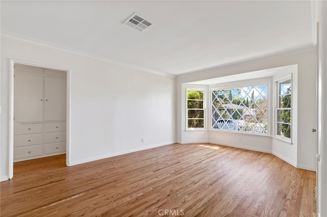 spare room featuring light hardwood / wood-style flooring and ornamental molding