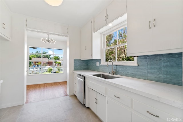 kitchen featuring white cabinets, sink, decorative backsplash, and a healthy amount of sunlight