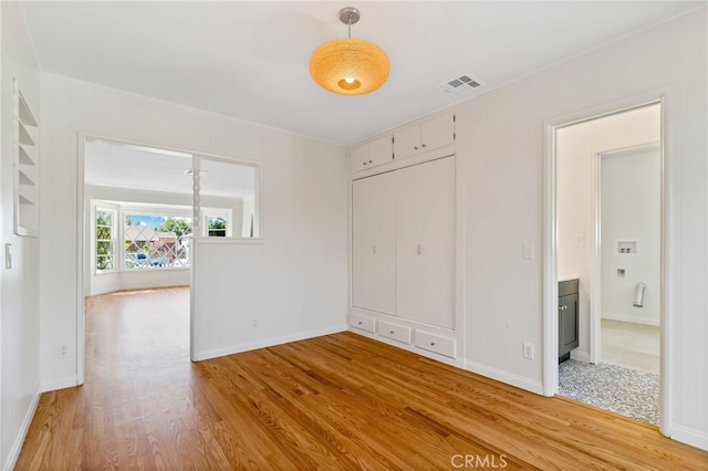 unfurnished bedroom featuring light hardwood / wood-style flooring and a closet